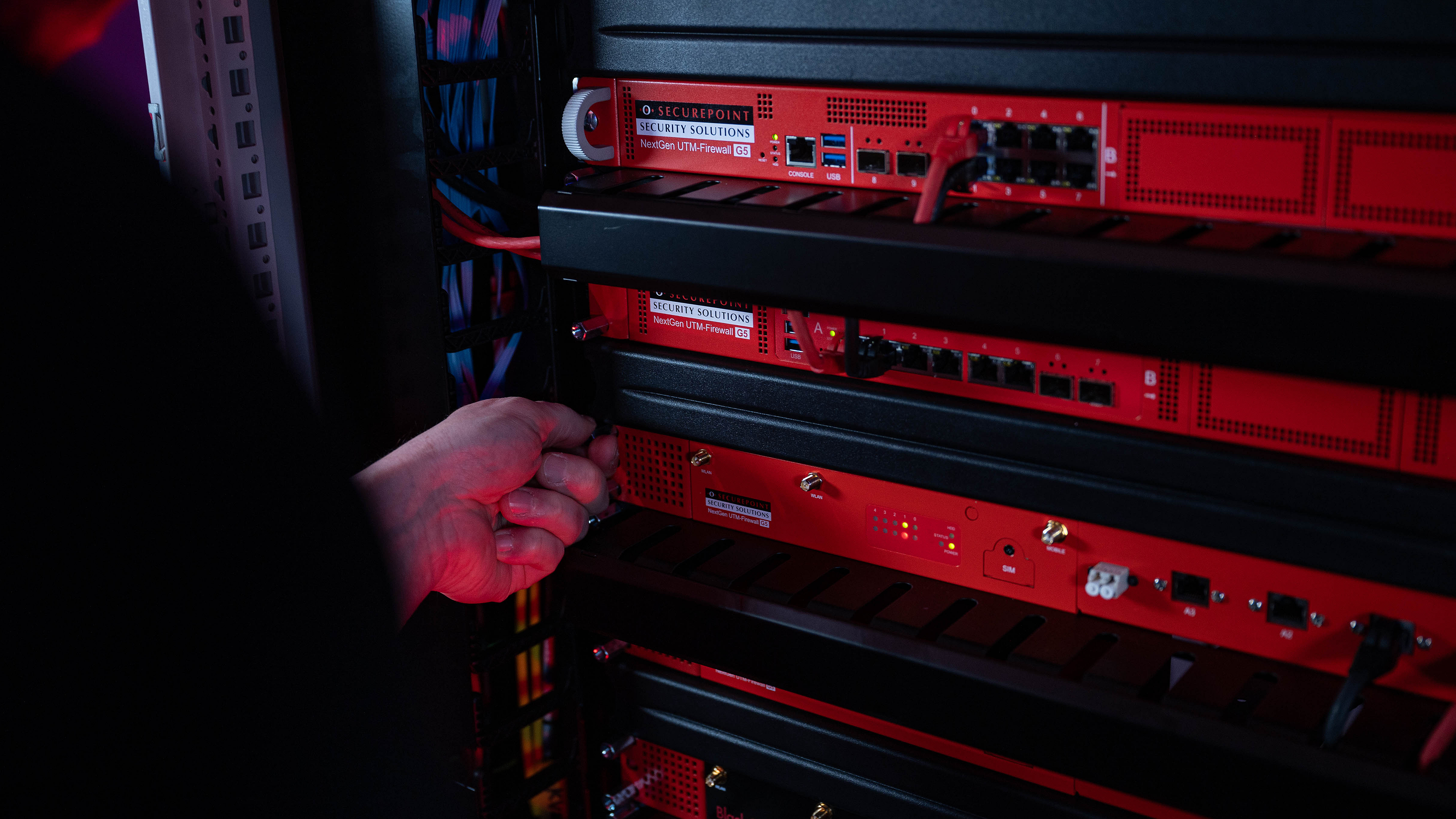 Ein Techniker schraubt eine Securepoint UTM-Firewall in ein Racksystem